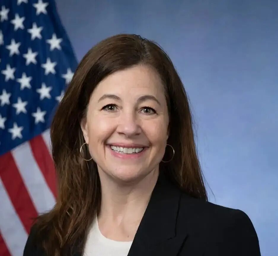 黑发女子的官方肖像，背景是美国国旗